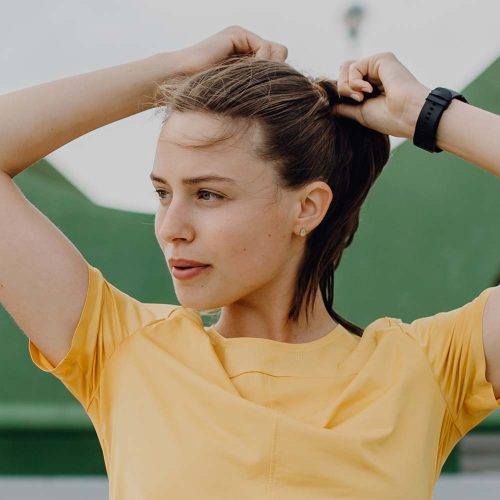 Portrait of young sportive woman resting outdoor in a city after running.